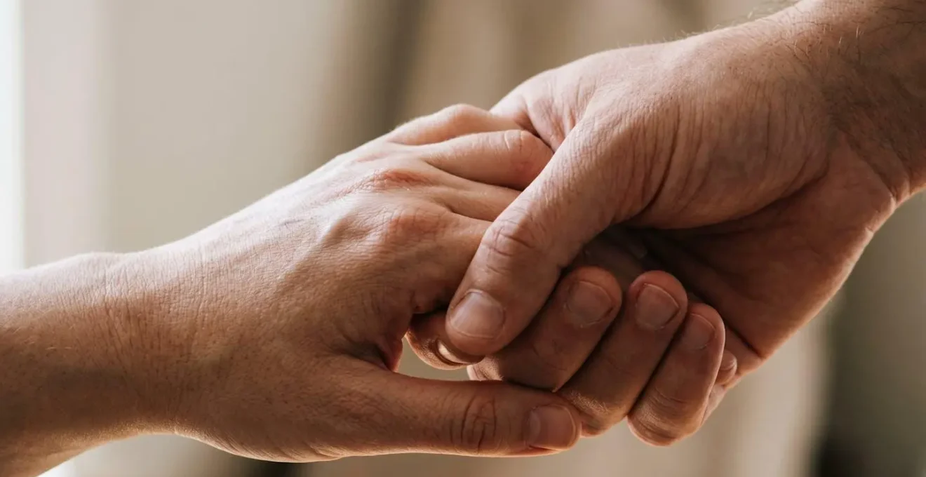 Main du partenaire tenant celle de la femme enceinte, soutien et présence rassurante pendant l'accouchement